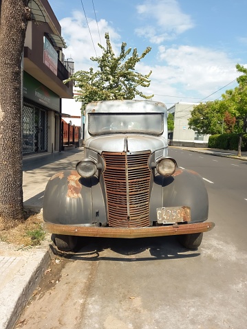 Buenos Aires, Argentina – October 03, 2022: Shot of an old vintage rusty 1938 Chevrolet Chevy panel delivery van parked in the street