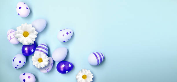 istock Easter holiday background with colorful easter eggs and white flowers on blue background. Top view from above. 1467319303
