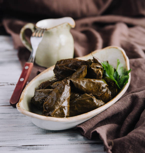 istock Dolma cabbage rolls grape leaves with filling and white sauce 1467319944