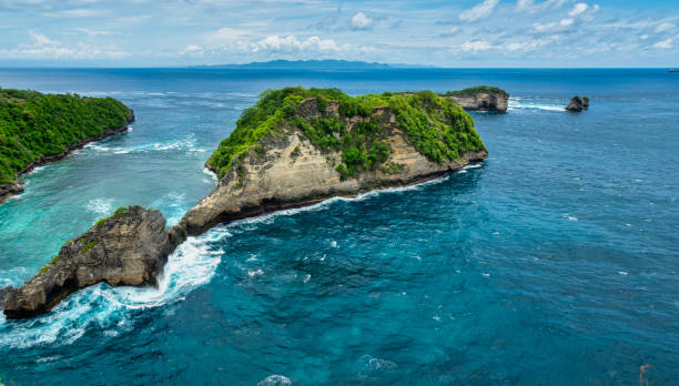 istock Atuh Beach is a Rustic, isolated cove beneath a sheer cliff face, with a sandy beach offshore rock formations. 1467320695