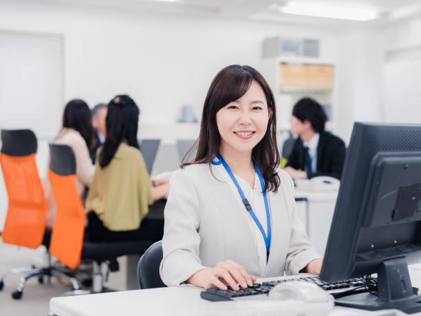 Woman working at a desk with a smile on her face stock photo