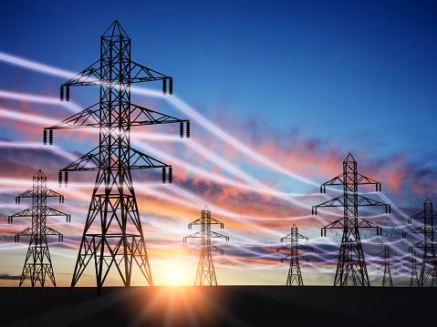 Electricity power pylons with sunset on background