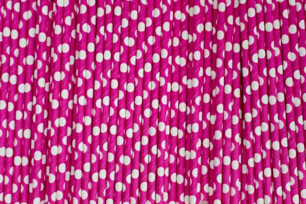 Abstract background image of pink coloured straws with white coloured round polka-dots