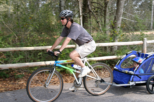 Caucasian father and son enjoying a bike ride on a country bike trail, intentional blur