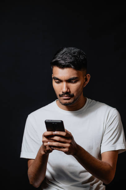 istock Young Indian male using cellphone, credit card in studio environment 1467335377