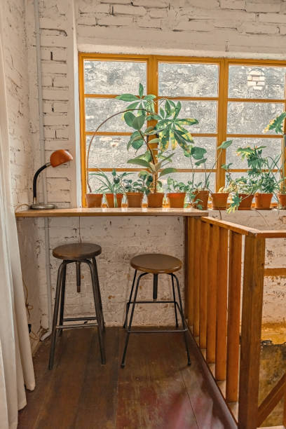 istock Cozy cafe interior by the window flowers and chairs 1467338572