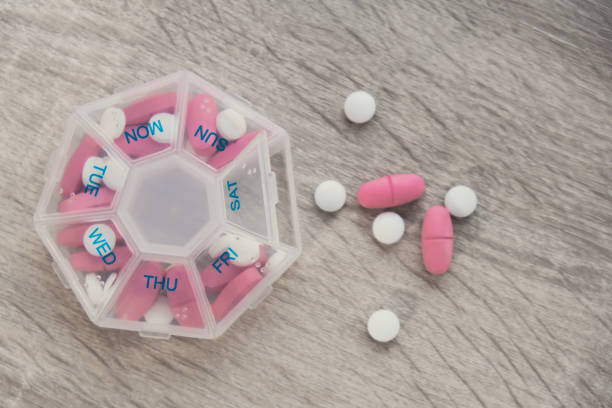 Organizer weekly shots Closeup of medical pill box with doses of tablets for daily take medicine with white pink drugs and capsules. Daily vitamins at home. Medication dietary supplements, immunity and disease prevention Fish oil softgel, vitamin D and C omega minerals, fiber, fatty amino acids, probiotics sedatives. Health care and diseases cure organizador de tomas semanales primer plano de la caja de píldoras médicas con dosis de tabletas para tomar diariamente medicamentos con medicamentos y cápsulas de color rosa blanco. vitaminas diarias en casa. cuidado de la salud y cura de enfermedades