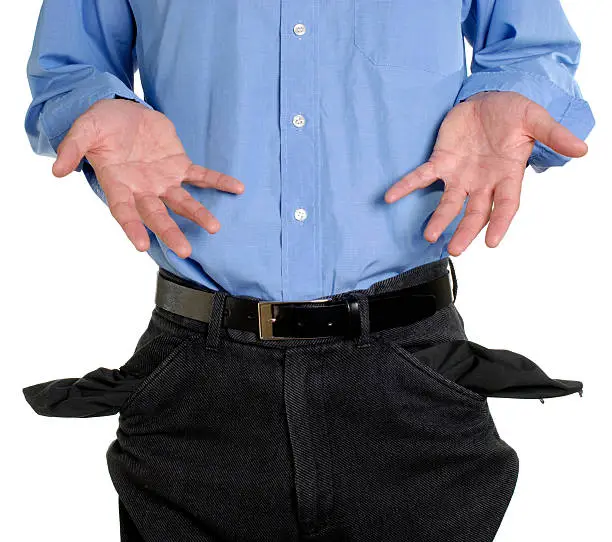 Conceptual shot of business man with empty pockets in tough economic times