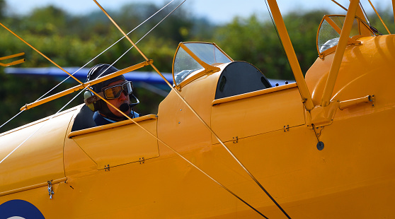 Little Gransden, Cambridge, England - August 28, 2022:  Yellow Tiger Moth Biplane close Up of  Pilot in Flying Goggles,