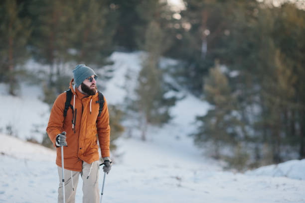 paysage hivernal, un homme avec un sac à dos et des vêtements d’hiver chauds dans la forêt, voyageant dans les montagnes. - trail marker hiking sign sports and fitness photos et images de collection