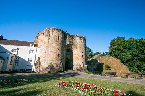 Tonbridge Castle in Kent, England. After William the Conqueror took England at the Battle of Hastings in 1066, his kinsman Richard Fitz Gilbert was tasked with guarding the crossing of the River Medway. He built a simple Motte-and-bailey castle. The castle was later besieged in 1088 when Fitz Gilber's descendants rebelled against William's son, King William II. The king had the castle and Tonbridge burnt to the ground in revenge. By 1100, a new wooden castle was replaced with a stone shell keep and in 1295 a stone wall encircled the town. The castle was used to safekeep the great seal of England for a while when King Edward I visited France. In 1793, the mansion was built, and both buildings are now Grade I listed.