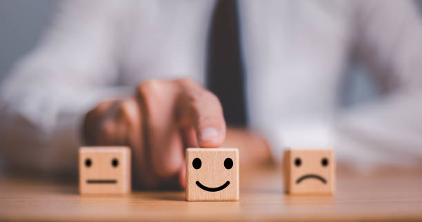 istock best excellent business services rating customer experience. Satisfaction survey concept. Hand of a businessman chooses a smiley face on wood block cube. 1467352316