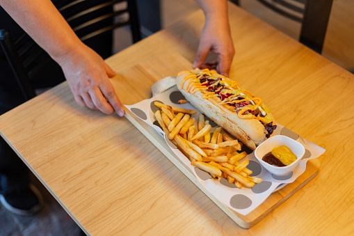 hot dog Colombian with fried on board on blue wooden table