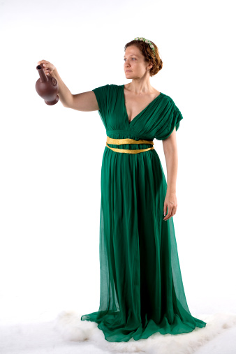 Lady in green antique dress handing jug on white background