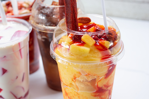 A view of a mangonada drink, with more refreshing Mexican drinks in the background.