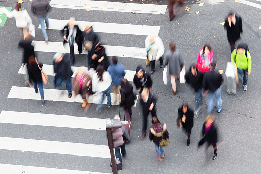high angle view of crowds of people crossing a city street at the zebra crossing