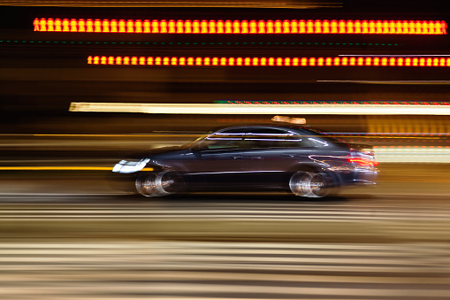 abstract blurred image of a driving car on a city street at night