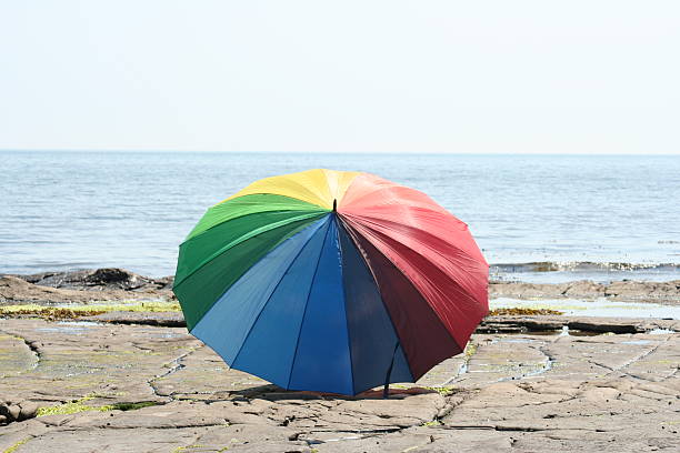 Raindow Umbrella on the seashore stock photo