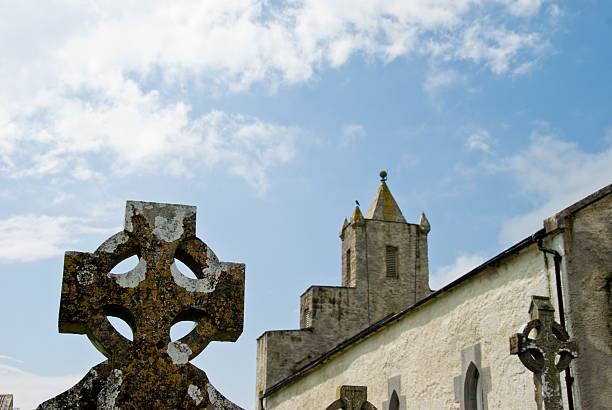 croix celtique en face de l'église irlandais - celtic cross republic of ireland cross shape cross photos et images de collection
