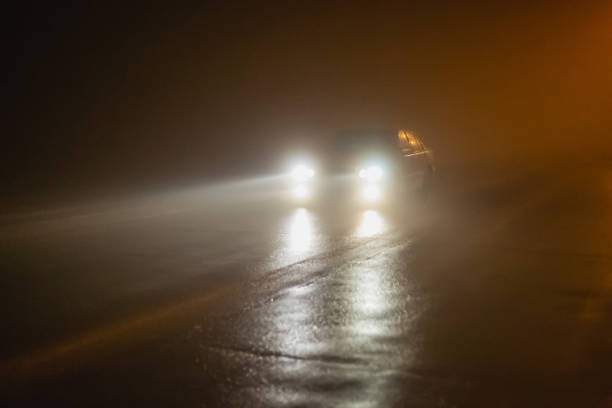 nevoeiro. cidade noturna. tempo úmido. silhueta do carro - street light fog morning country road - fotografias e filmes do acervo