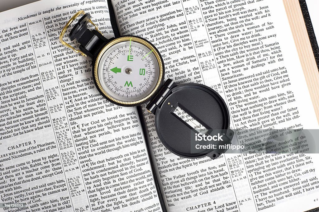 Compass on Bible An engineers directional compass on a Bible, concept of guidance or direction Bible Stock Photo