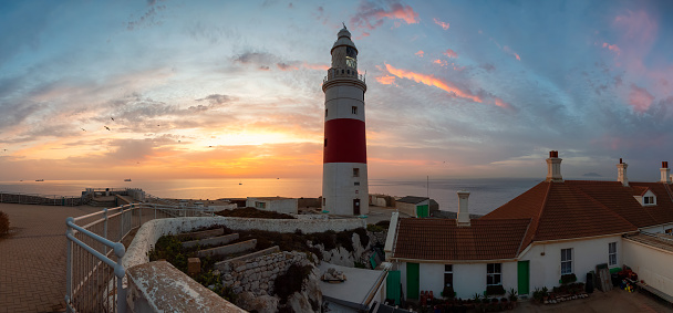 Europa Point Lighthouse with sea in background. Colorful Cloudy Sunrise Sky. Gibraltar, United Kingdom. Panorama
