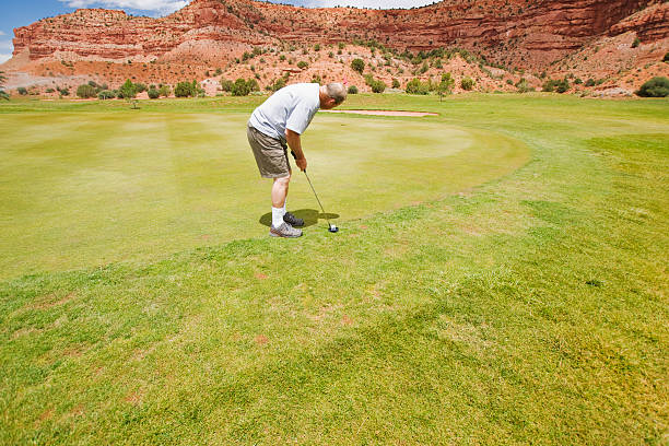 Concentrarse mientras que en el hermoso campo de golf en el putting green. - foto de stock