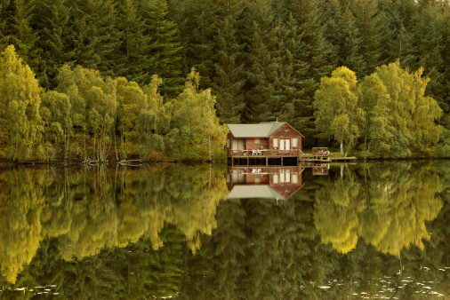 Reflections of a remote fishing hut in autumn