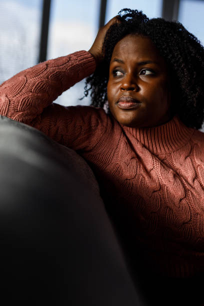 istock Anxious young woman sitting on the sofa, looking away, worrying 1467374204