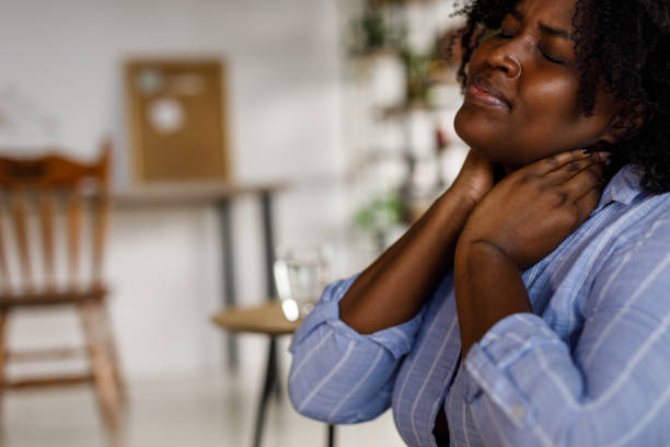istock Student sitting on the floor, taking a break from studying and stretching her painful neck 1467374886