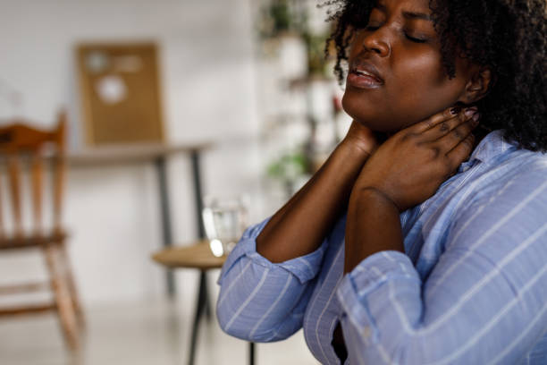 istock Student sitting on the floor, taking a break from studying and stretching her painful neck 1467374939