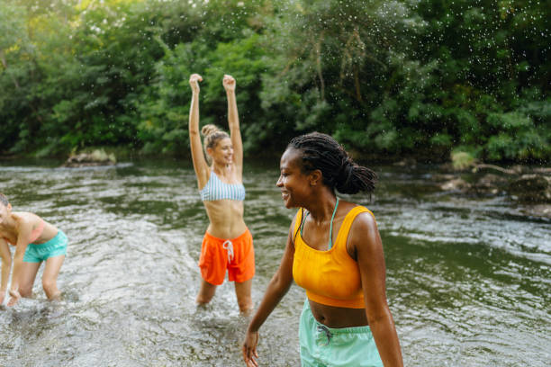 Photo of female friends spending hot summer day by the river