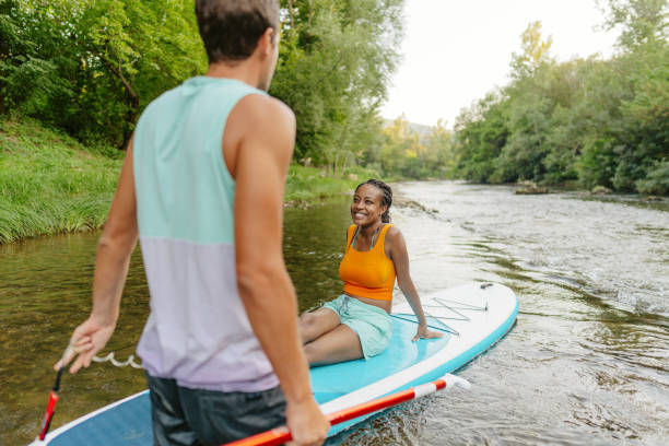 istock Multiracial couple riding a SUP paddleboard together 1467375604