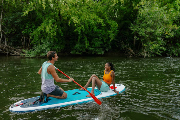 istock Multiracial couple riding a SUP paddleboard together 1467375645