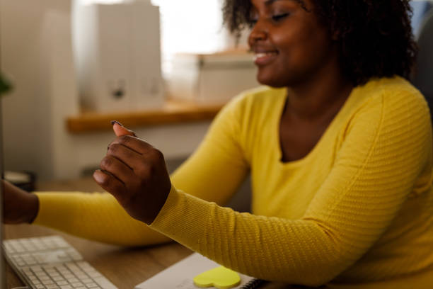 istock Young woman putting a sticky note with a reminder on her desktop computer 1467376293