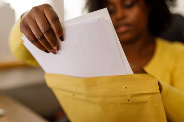 istock Businesswoman packing documents from a yellow envelope 1467376582