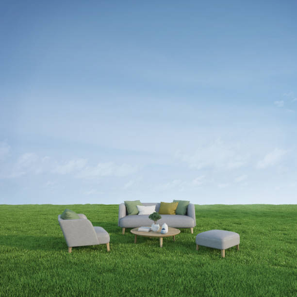 istock Sofa armchair and table in green meadow grass with blue sky background.3d rendering 1467384560