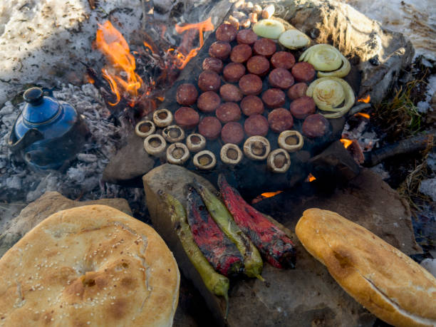 istock Camping meal preparation over wood fire and count stone 1467389806