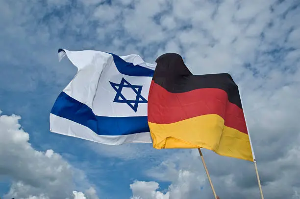 Flag of Israel an Germany are joining in the cloudy sky