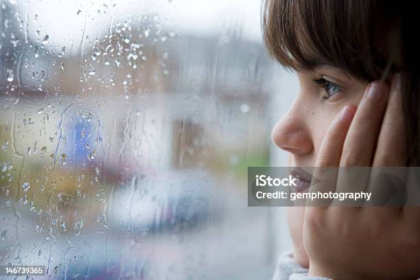 Girl Looking Out A Rain Splattered Window Stock Photo - Download Image Now - Rain, Child, Looking Through Window