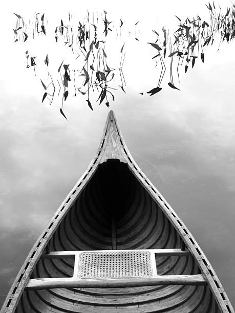 wooden canoe on lake, black and white stock photo