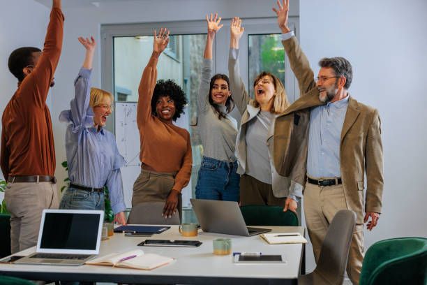 istock Joyful business team members celebrate in office. 1467403440