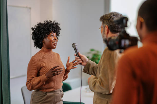 istock Cheerful office worker being interviewed by TV crew. 1467404929