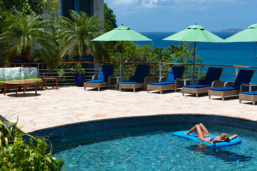 Bikini woman relaxing in pool at Luxury villa in Peter bay, Cinnamon Bay, St. John