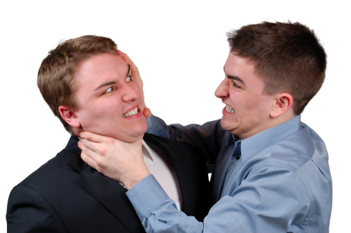 Young man in a dress shirt strangling a young man in a business suit. Isolated
