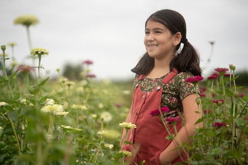 Eight years old hispanic girl standing on a flower field