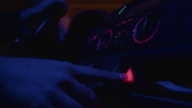 istock Close-Up Hand Pushing the Flashing Hazard Lights Button in a Car Interior, Highlighting the Importance of Road Safety, Emergency - 1467410487