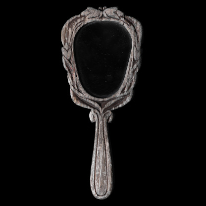 Beauty, fashion, style, make-up and personal accessories concept. Retro vintage hand mirror with wooden ornate frame isolated on black background. Grunge and dusty mirror surface. Copy space