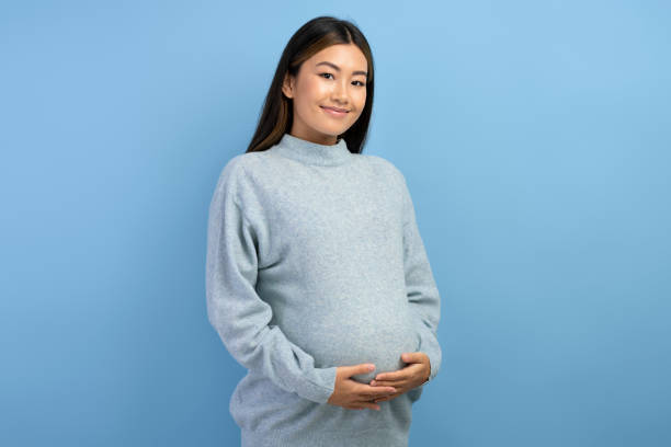 Image of a beautiful young pregnant asian woman posing isolated stock photo