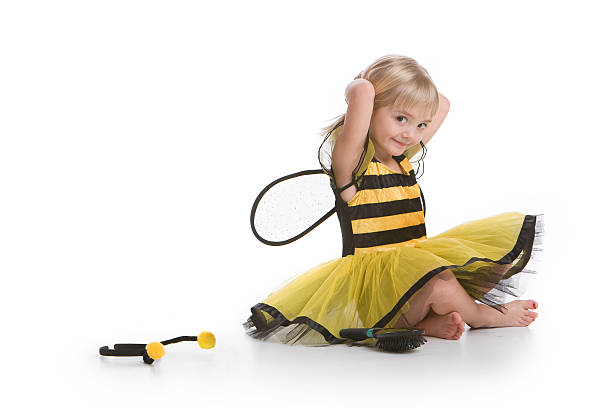 Bumblebee girl Cute little girl styling her hair and smiling at camera with a bumblebee costume on a white background bee costume stock pictures, royalty-free photos & images